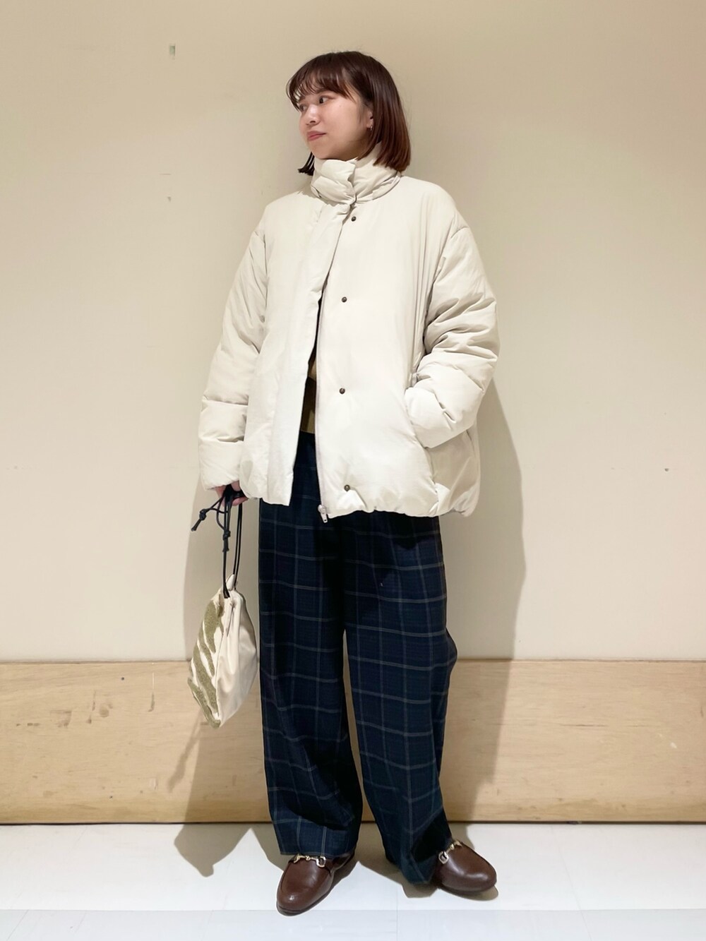 グリーン系のニット/セーター、ホワイト系のダウンジャケット/コート、ブラウン系のローファーを着用したレディースの秋コーディネートの8枚目の写真