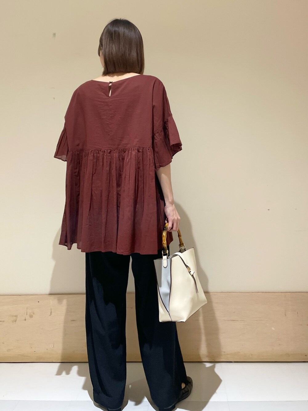 レッド系のシャツ/ブラウス、ブラック系のその他パンツ、ホワイト系のハンドバッグを着用したレディースの秋コーディネートの7枚目の写真