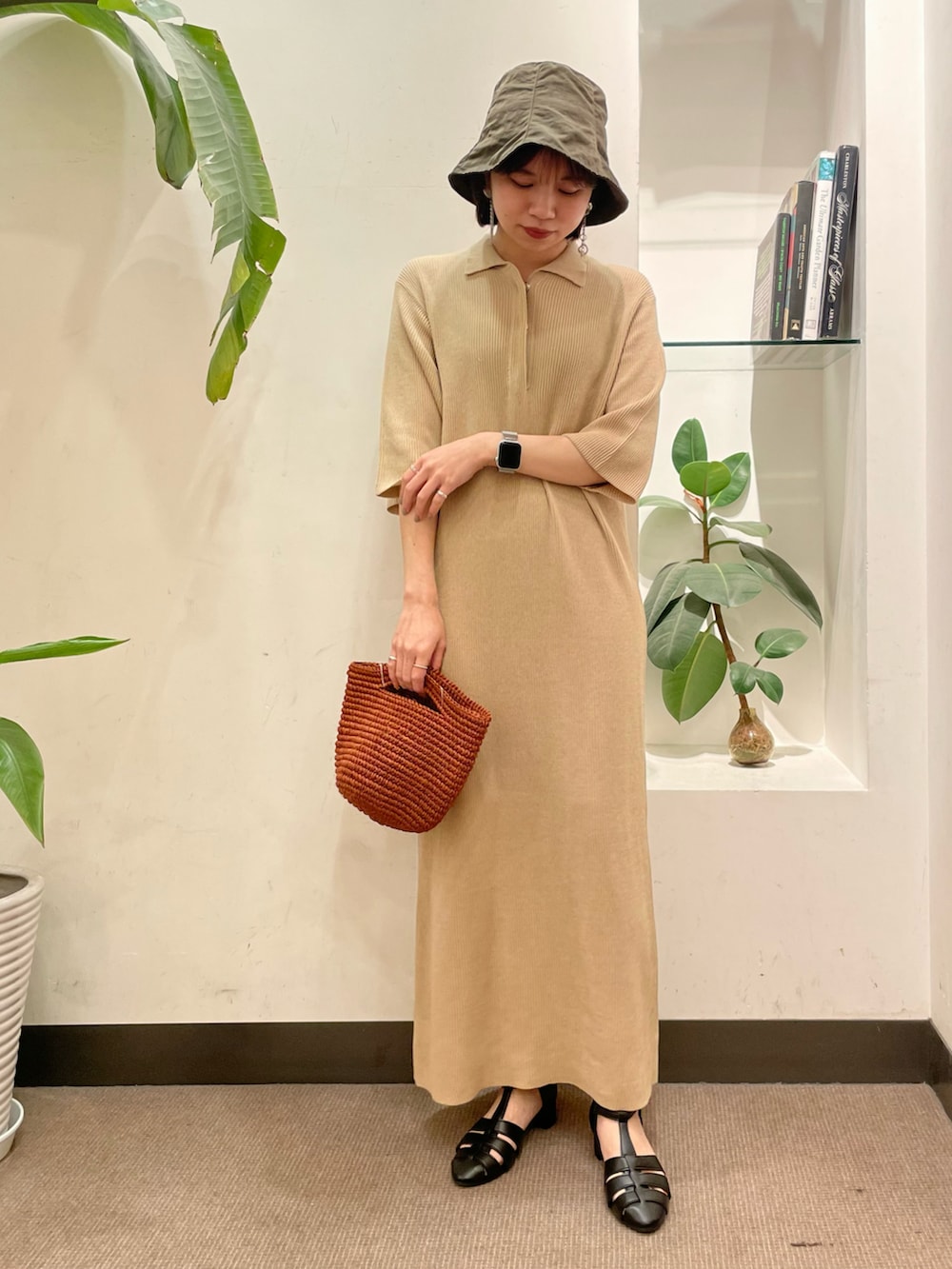 ブラック系のサンダル、ベージュ系のワンピース、グリーン系のハットを着用したレディースの夏コーディネートの2枚目の写真