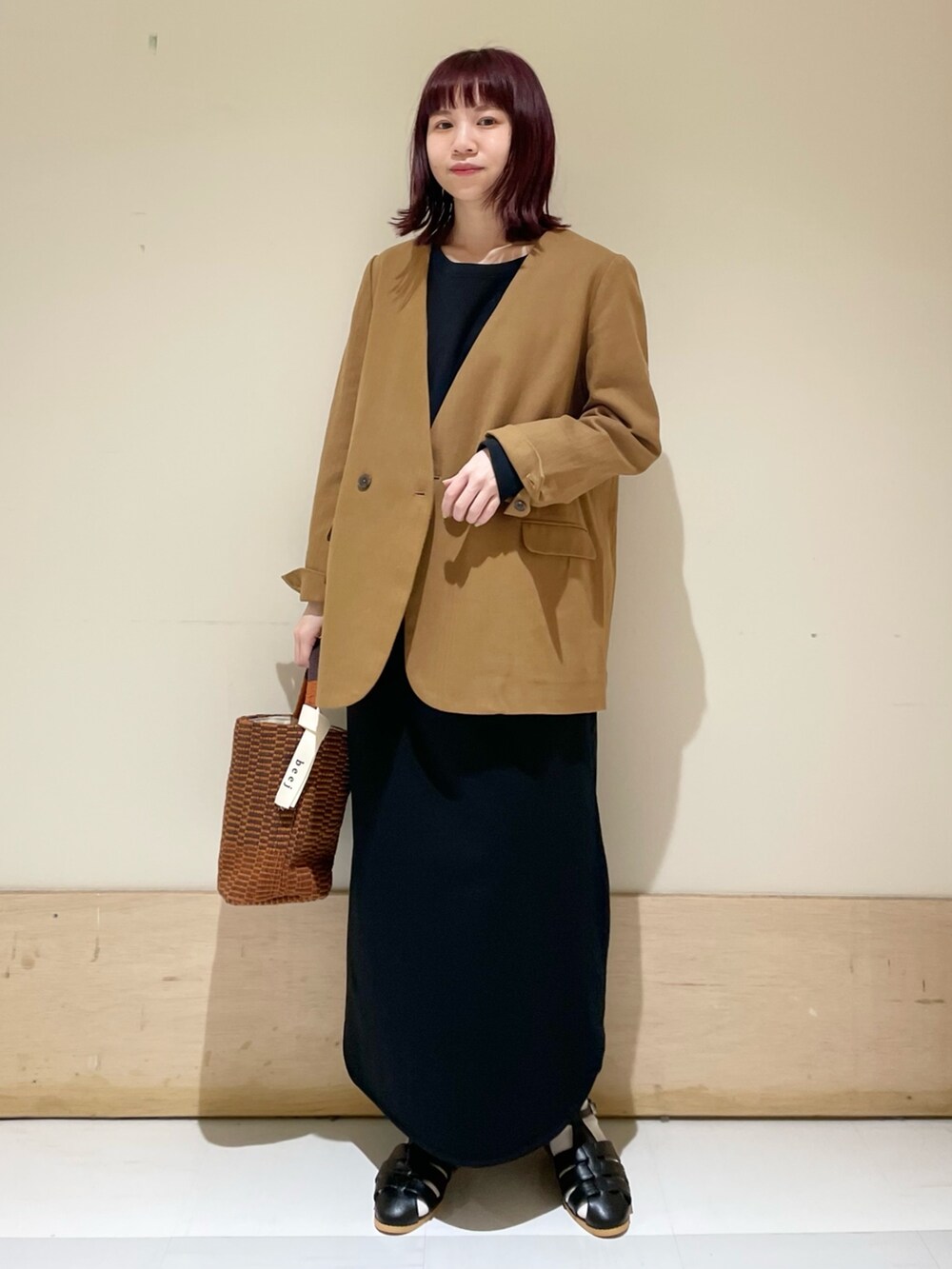ブラック系のワンピース、ベージュ系のノーカラージャケット、ブラック系のサンダルを着用したレディースの春コーディネートの4枚目の写真