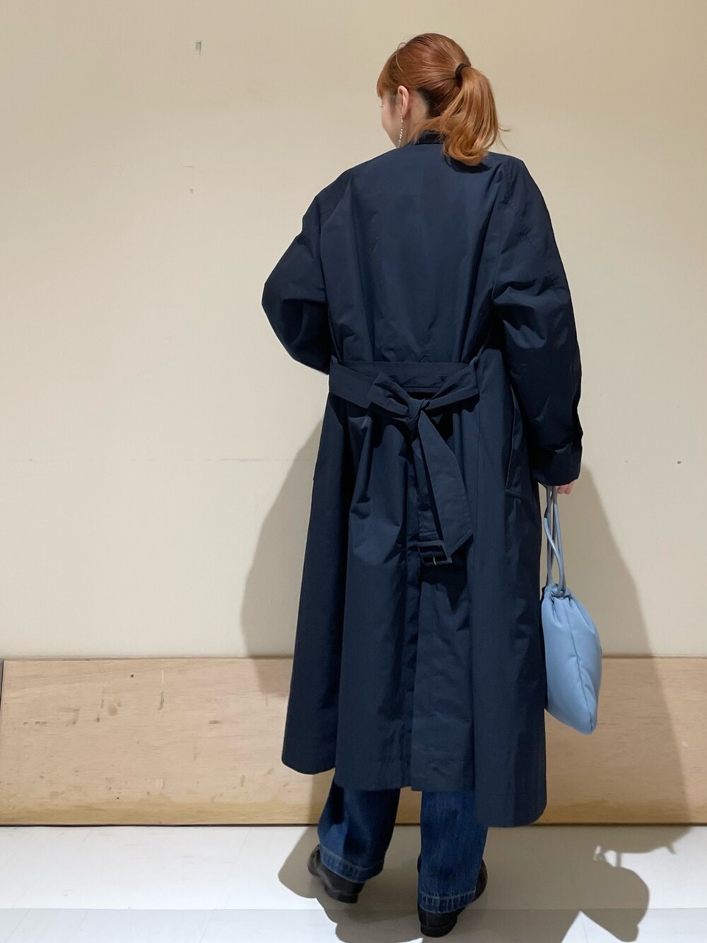 ホワイト系のシャツ/ブラウス、ブルー系のステンカラーコート、ブルー系のデニムパンツを着用したレディースの春コーディネートの3枚目の写真