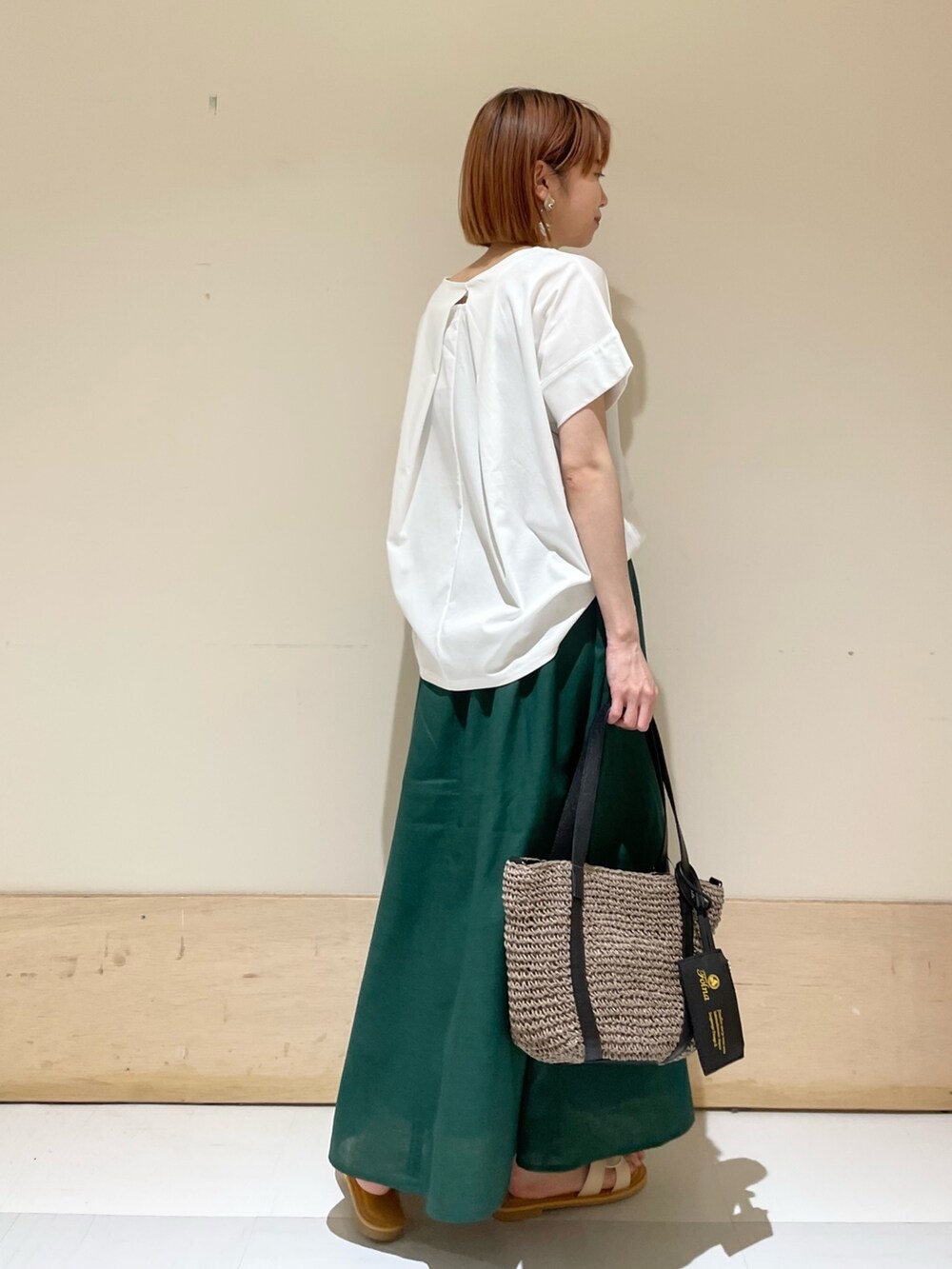 ホワイト系のTシャツ/カットソー、グレー系のトートバッグ、グリーン系のスカートを着用したレディースの夏コーディネートの5枚目の写真