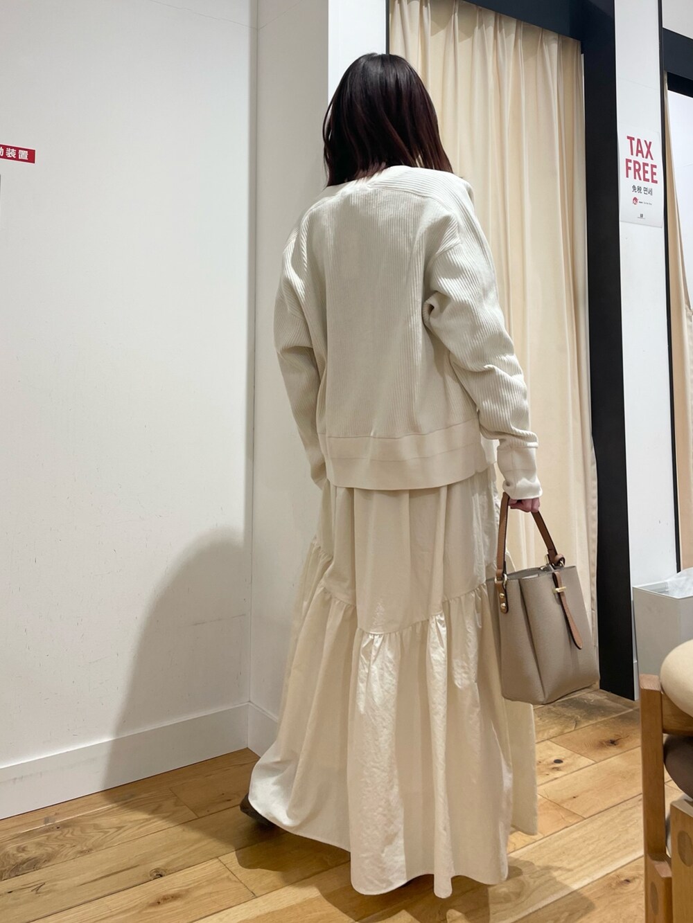 ホワイト系のカーディガン/ボレロ、ブラック系のTシャツ/カットソー、ホワイト系のスカートを着用したレディースの春コーディネートの6枚目の写真