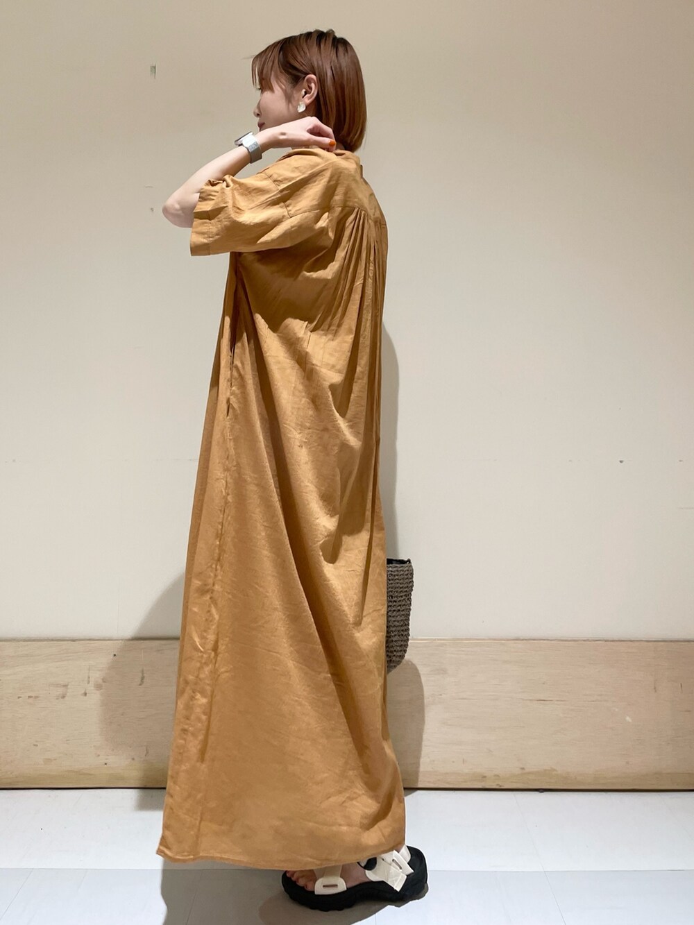 ブラウン系のワンピース、ホワイト系のサンダル、グレー系のトートバッグを着用したレディースの夏コーディネートの5枚目の写真