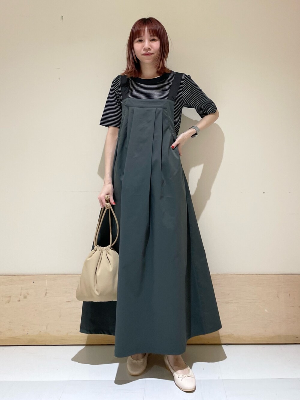 ベージュ系のショルダーバッグ、ピンク系のバレエシューズ、ホワイト系のTシャツ/カットソーを着用したレディースの春コーディネートの4枚目の写真