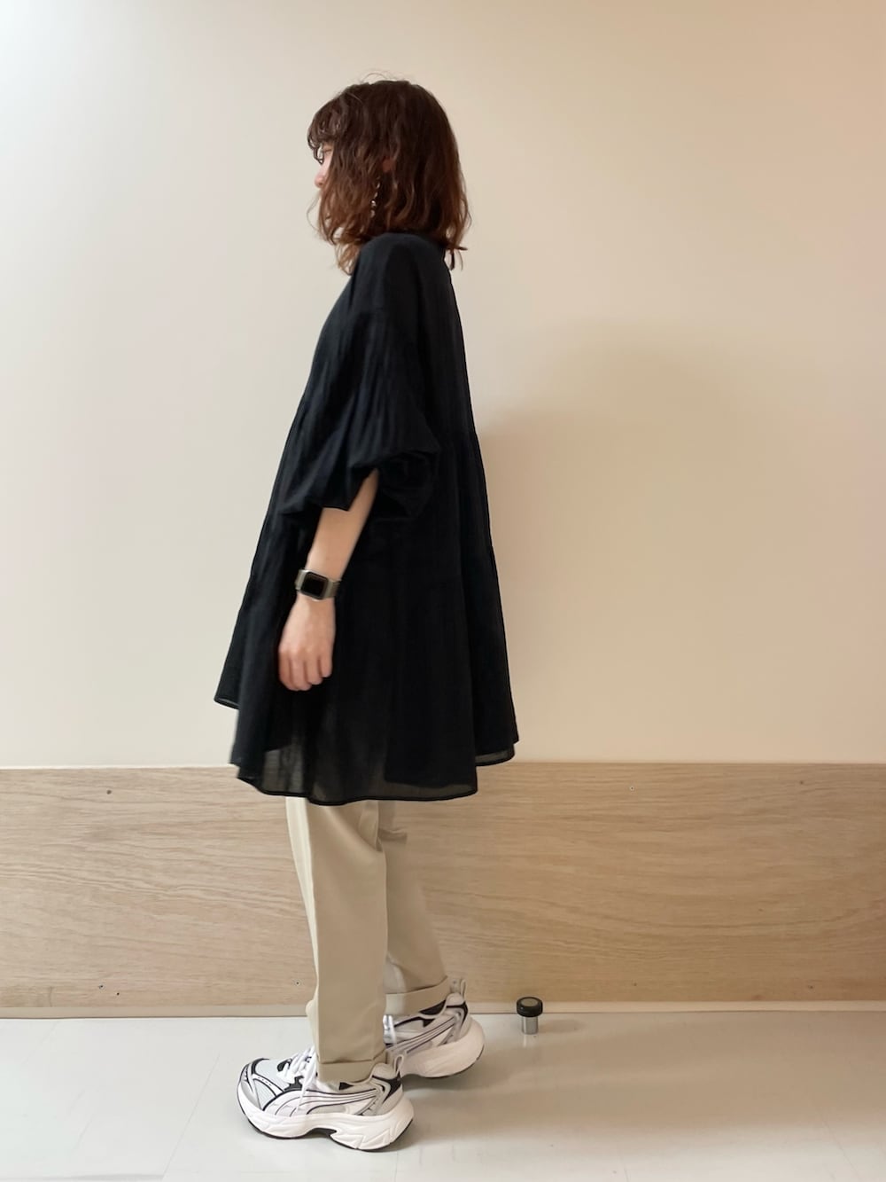 ブラック系のチュニック、ベージュ系のその他パンツを着用したレディースの春コーディネートの5枚目の写真