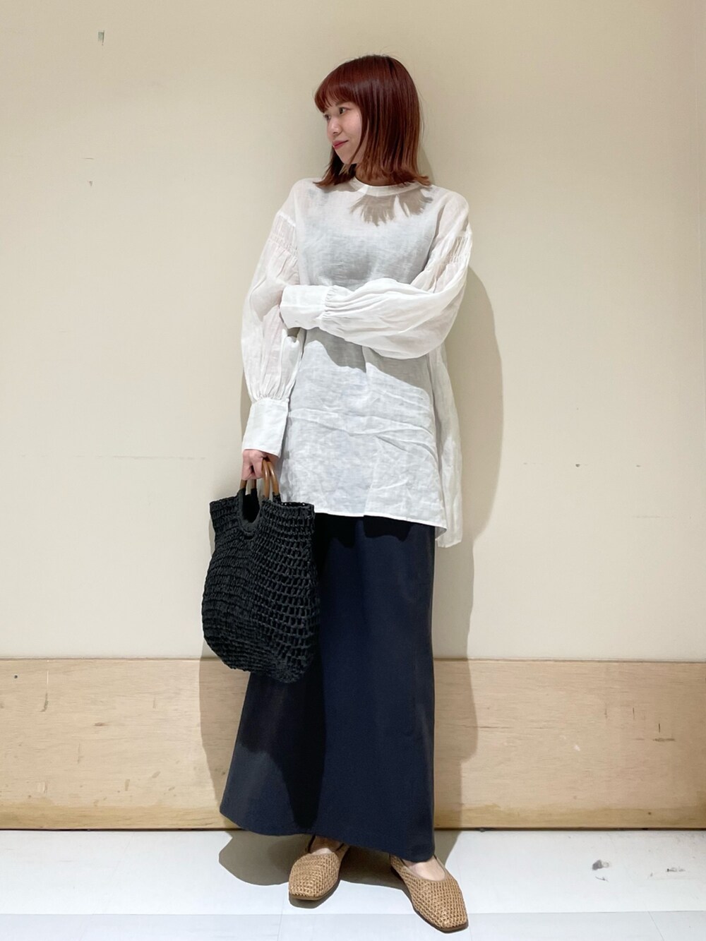 ホワイト系のシャツ/ブラウス、グレー系のスカート、ブラック系のかごバッグを着用したレディースの春コーディネートの6枚目の写真