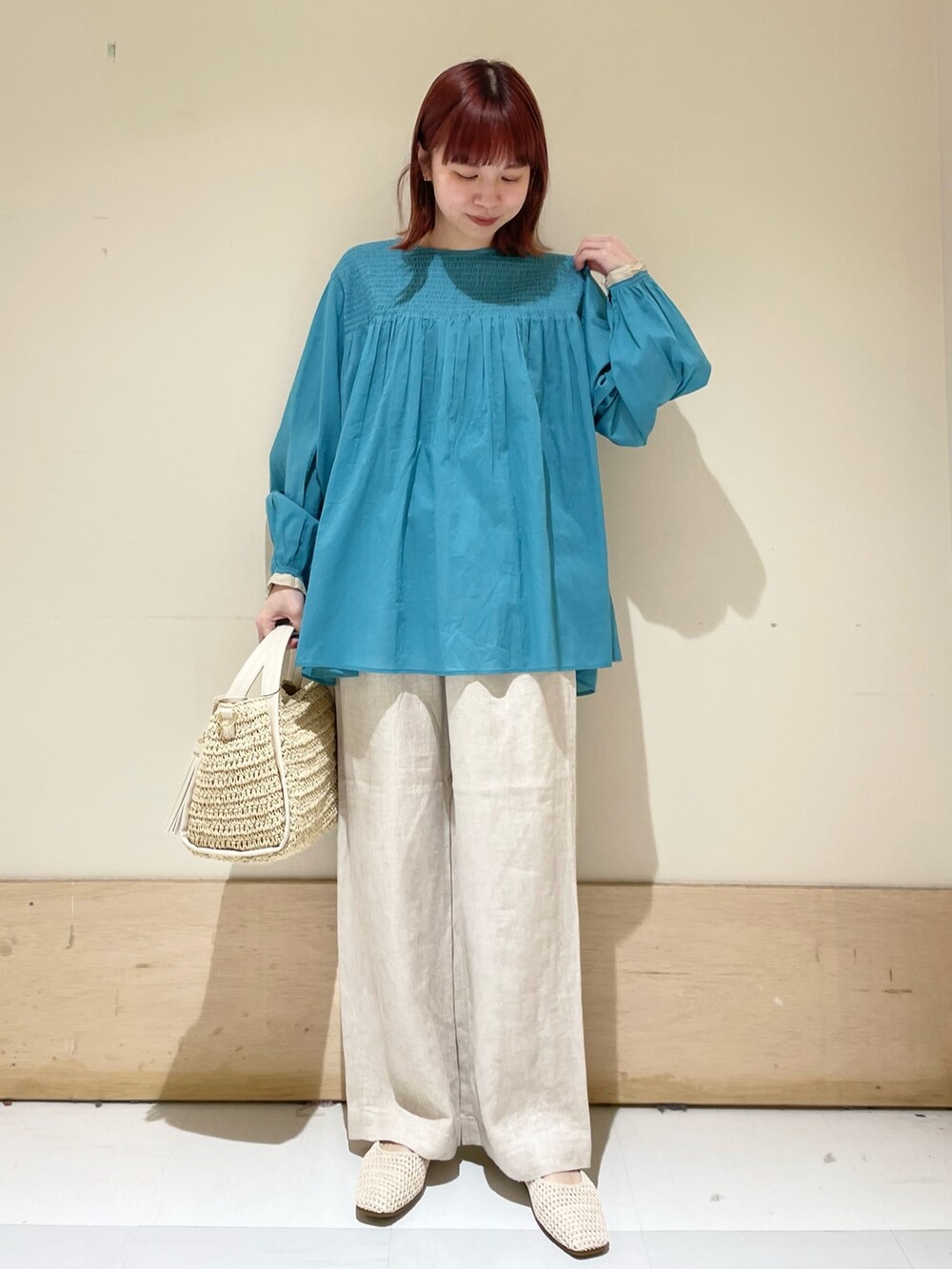 ブルー系のシャツ/ブラウス、ホワイト系のバレエシューズ、ベージュ系のかごバッグを着用したレディースの春コーディネートの2枚目の写真