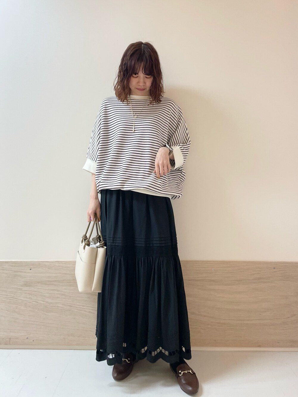 ブラウン系のローファー、ブラック系のスカート、ホワイト系のTシャツ/カットソーを着用したレディースの春コーディネートの2枚目の写真