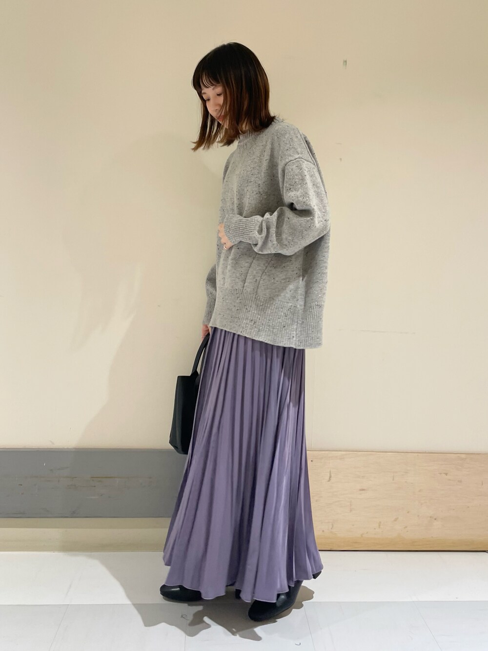 ブラック系のトートバッグ、パープル系のスカート、グレー系のニット/セーターを着用したレディースの冬コーディネートの2枚目の写真