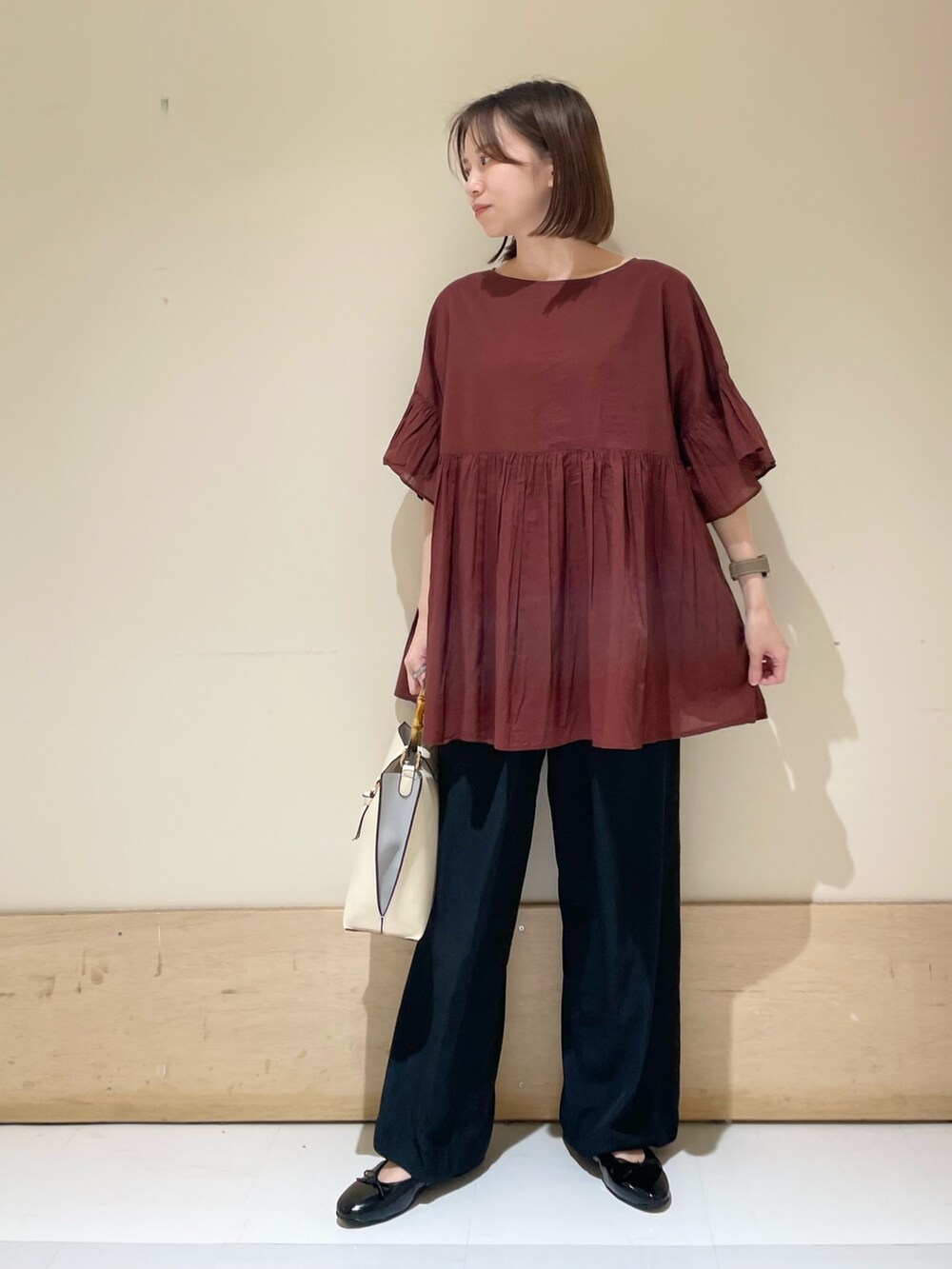 レッド系のシャツ/ブラウス、ブラック系のその他パンツ、ホワイト系のハンドバッグを着用したレディースの秋コーディネートの2枚目の写真