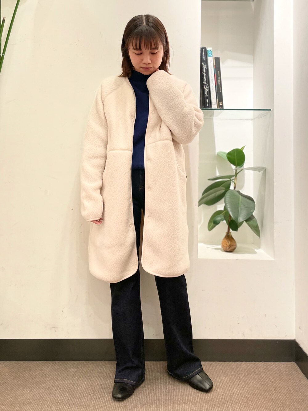 ブルー系のデニムパンツ、ブルー系のニット/セーター、ホワイト系のジャケット/アウターを着用したレディースの秋コーディネートの2枚目の写真