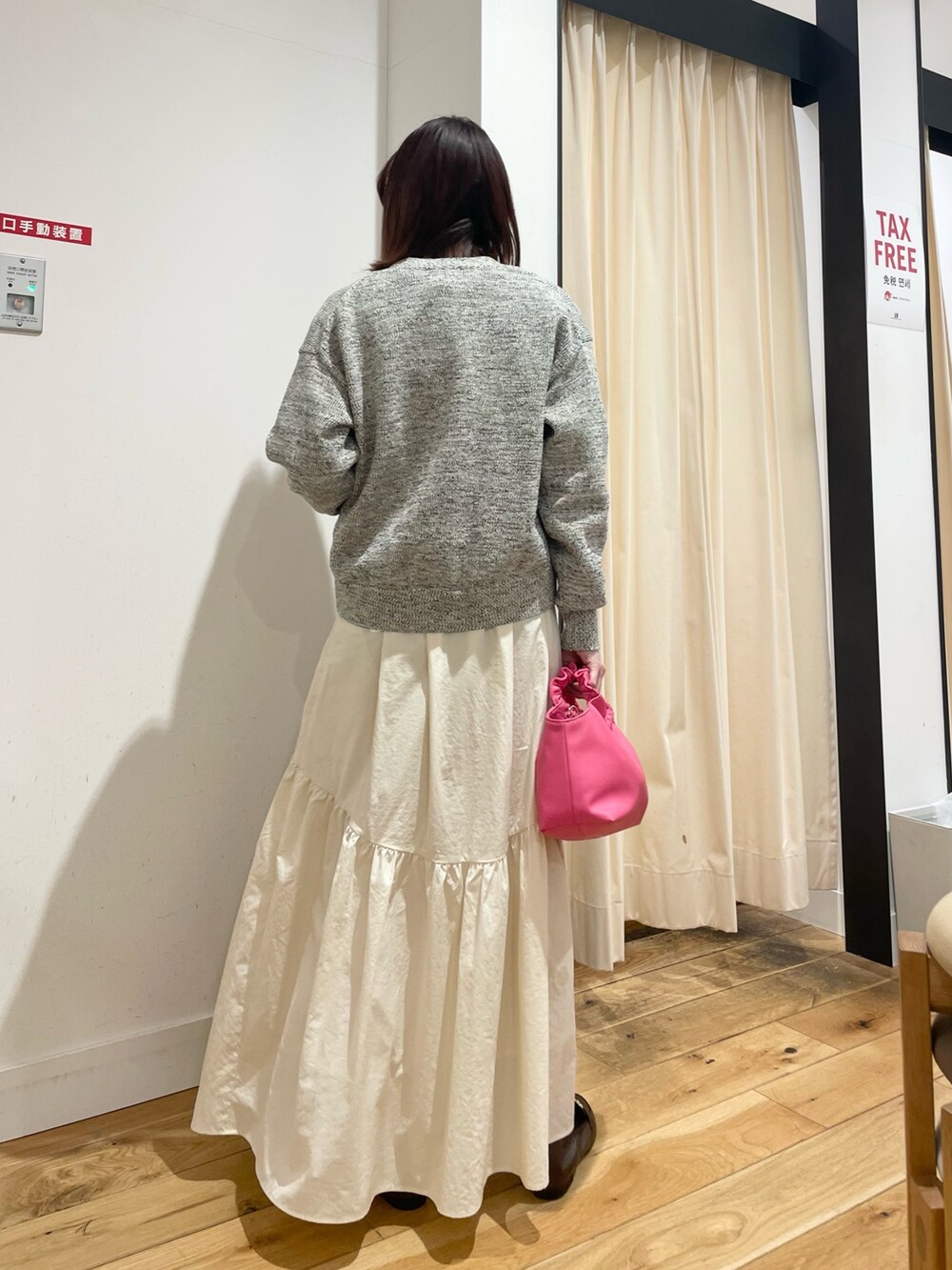 ブルー系のニット/セーター、ブルー系のカーディガン/ボレロ、ホワイト系のスカートを着用したレディースの春コーディネートの4枚目の写真