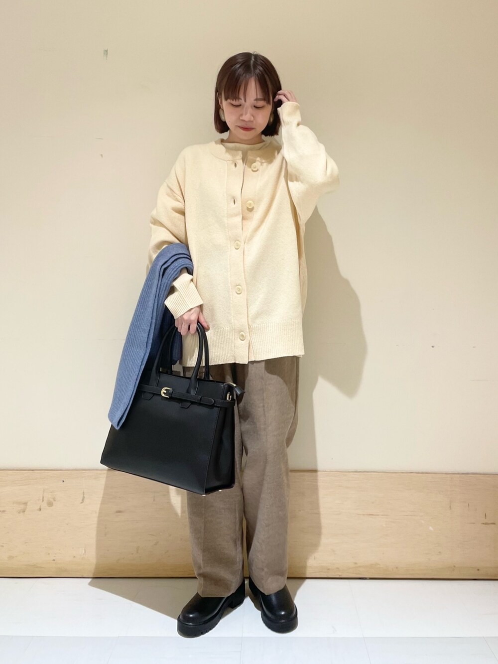 ホワイト系のニット/セーター、ホワイト系のカーディガン/ボレロ、ベージュ系のその他パンツを着用したレディースの秋コーディネートの2枚目の写真
