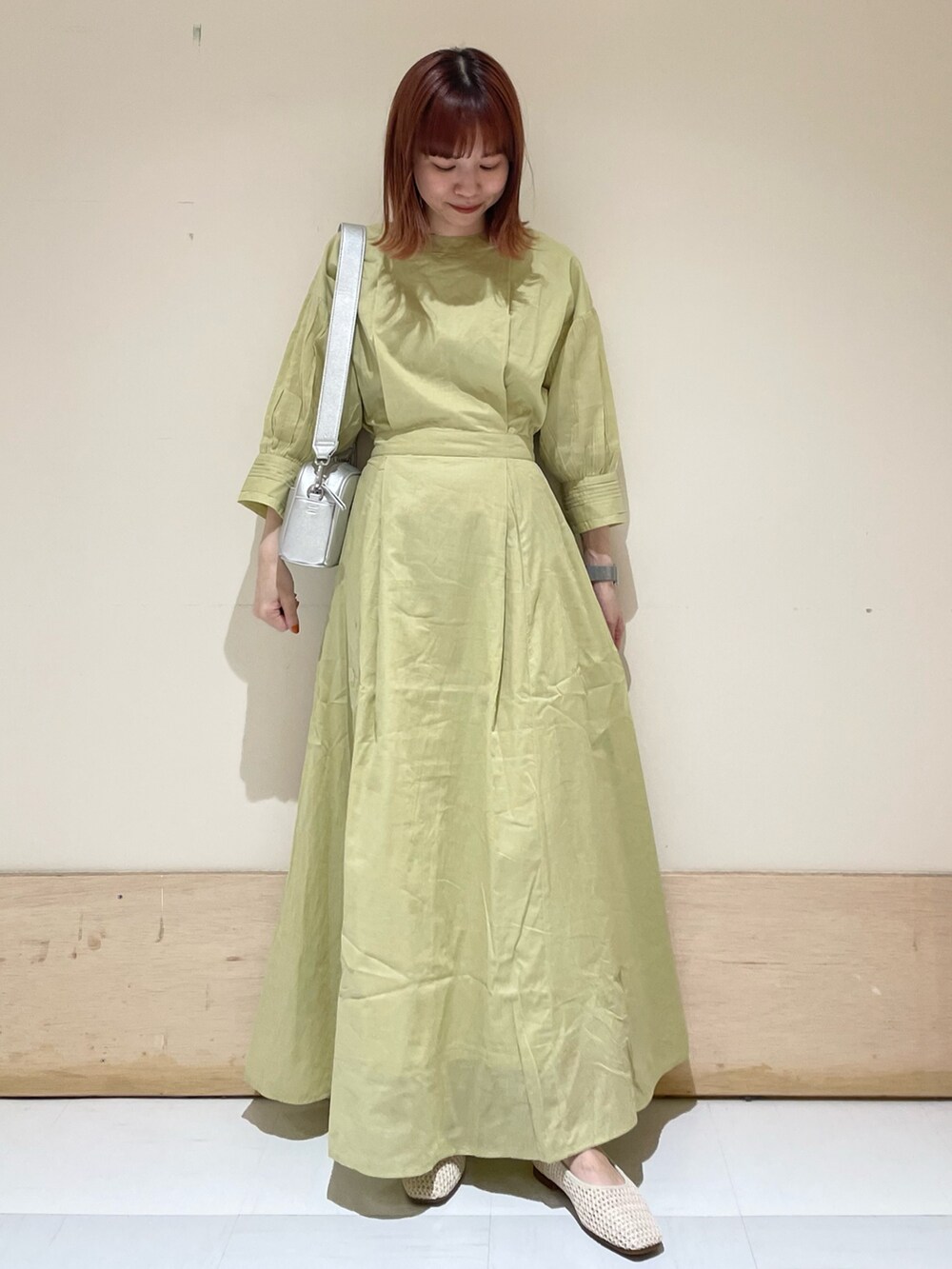 グリーン系のワンピース、シルバー系のショルダーバッグ、ホワイト系のパンプスを着用したレディースの春コーディネートの4枚目の写真