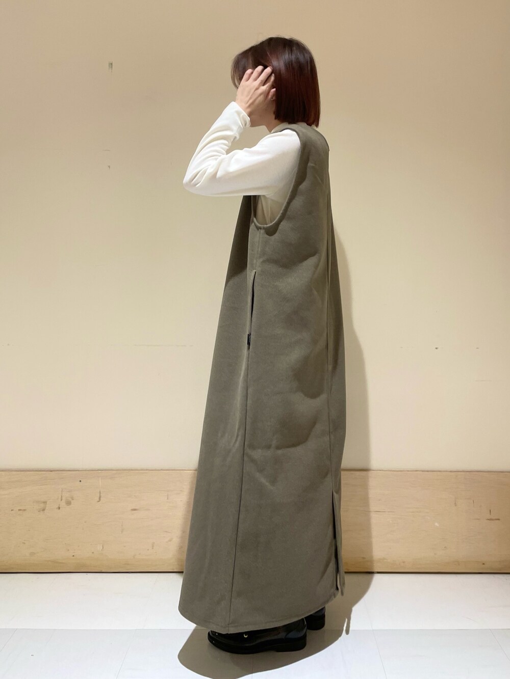 ブラウン系のワンピース、ホワイト系のTシャツ/カットソー、ブラック系のショルダーバッグを着用したレディースの秋コーディネートの5枚目の写真