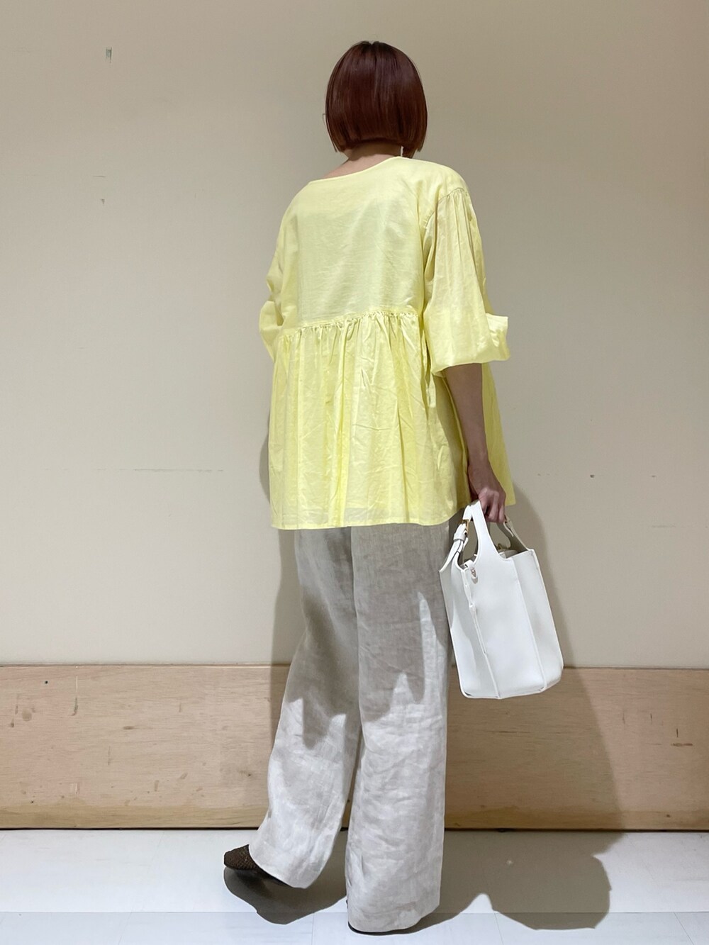 ベージュ系のその他パンツ、イエロー系のシャツ/ブラウス、ホワイト系のトートバッグを着用したレディースの春コーディネートの8枚目の写真