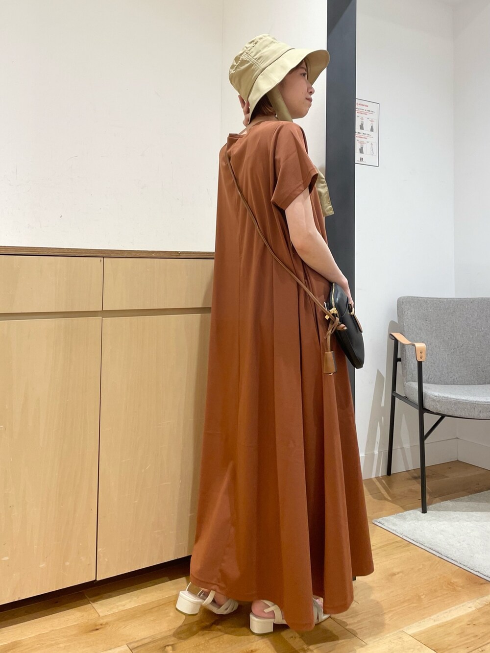 ホワイト系のサンダル、ブラウン系のワンピース、ブラック系のショルダーバッグを着用したレディースの夏コーディネートの6枚目の写真