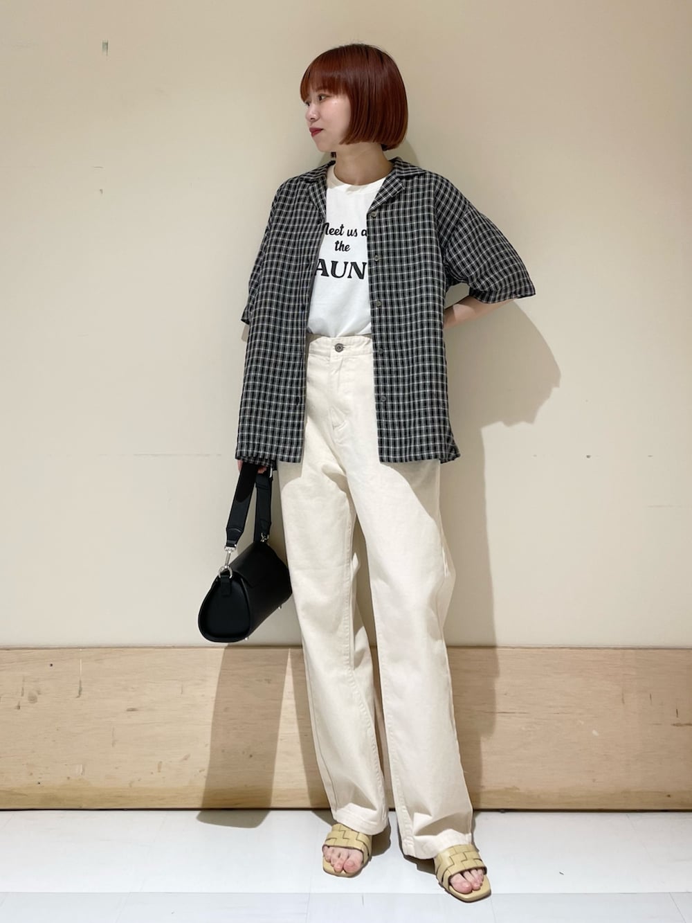 ホワイト系のTシャツ/カットソー、ベージュ系のデニムパンツ、ブラック系のショルダーバッグを着用したレディースの春コーディネートの6枚目の写真