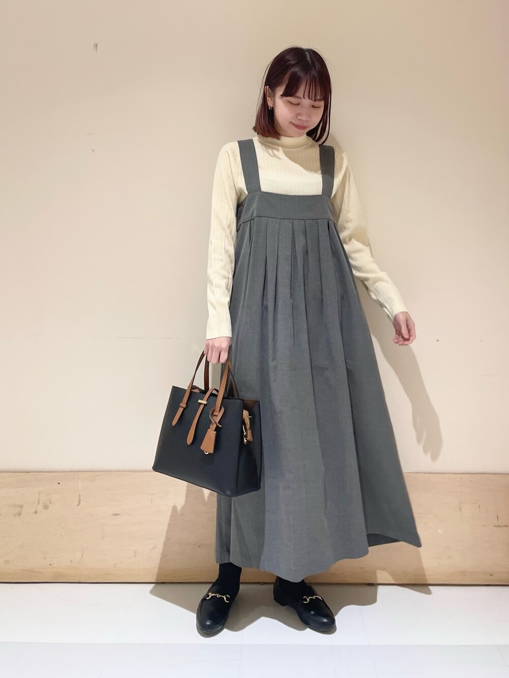 グレー系のワンピース、ホワイト系のニット/セーターを着用したレディースの冬コーディネートの2枚目の写真