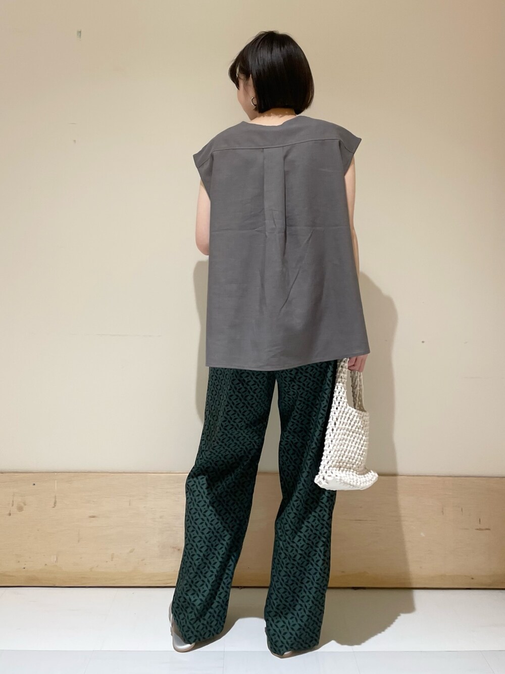 グレー系のシャツ/ブラウス、ホワイト系のハンドバッグ、シルバー系のサンダルを着用したレディースの夏コーディネートの7枚目の写真