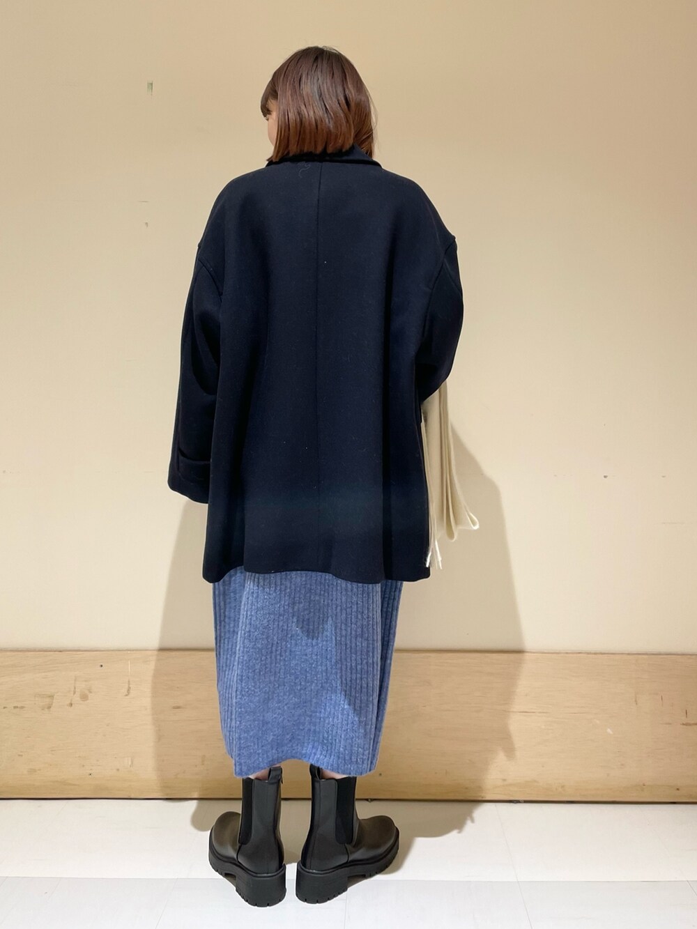 ブルー系のワンピース、ブルー系のその他アウター、ブラック系のブーツを着用したレディースの冬コーディネートの6枚目の写真