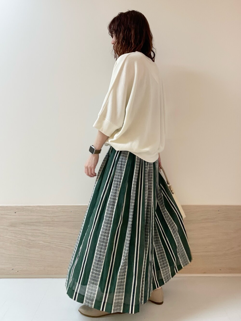 ホワイト系のTシャツ/カットソー、グリーン系のスカート、ベージュ系のパンプスを着用したレディースの春コーディネートの4枚目の写真