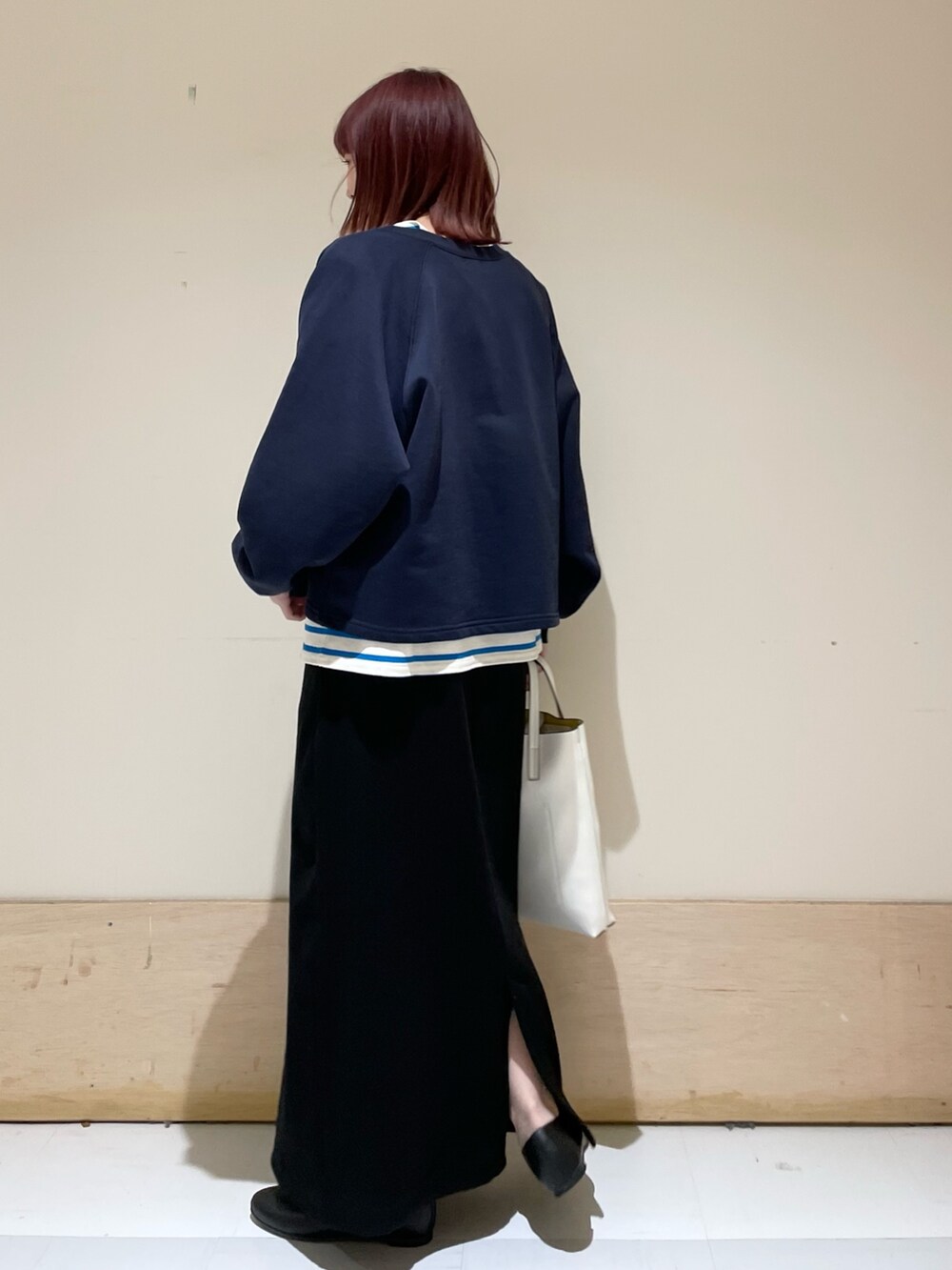 ブルー系のニット/セーター、ブルー系のTシャツ/カットソー、ブラック系のパンプスを着用したレディースの春コーディネートの5枚目の写真