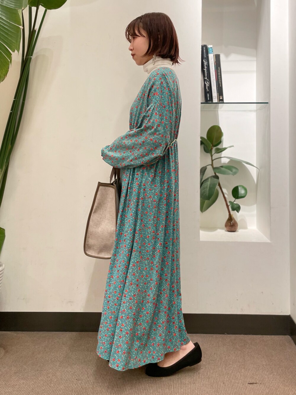 ブラック系のバレエシューズ、グリーン系のワンピース、ホワイト系のTシャツ/カットソーを着用したレディースの冬コーディネートの3枚目の写真