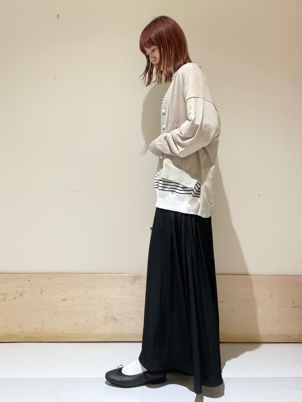 ブラック系のスカート、ホワイト系のTシャツ/カットソー、ベージュ系のカーディガン/ボレロを着用したレディースの春コーディネートの5枚目の写真