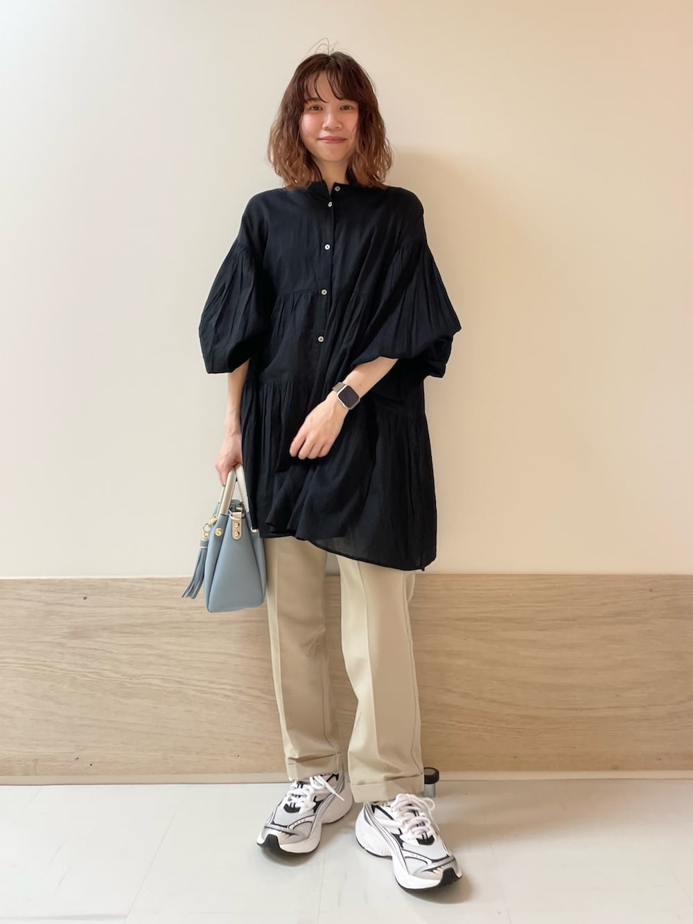 ブラック系のチュニック、ベージュ系のその他パンツを着用したレディースの春コーディネートの3枚目の写真