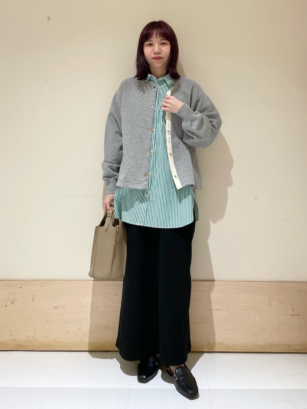 グレー系のカーディガン/ボレロ、グリーン系のシャツ/ブラウス、ブラック系のスカートを着用したレディースの春コーディネートの2枚目の写真