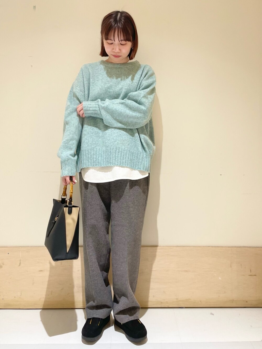 グリーン系のニット/セーター、ホワイト系のTシャツ/カットソー、グレー系のその他パンツを着用したレディースの冬コーディネートの3枚目の写真