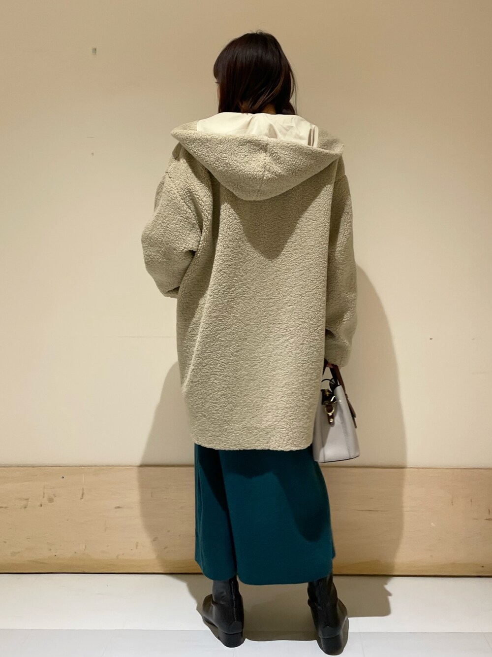 ベージュ系のその他アウター、ブルー系のワンピース、ブラック系のブーツを着用したレディースの冬コーディネートの3枚目の写真