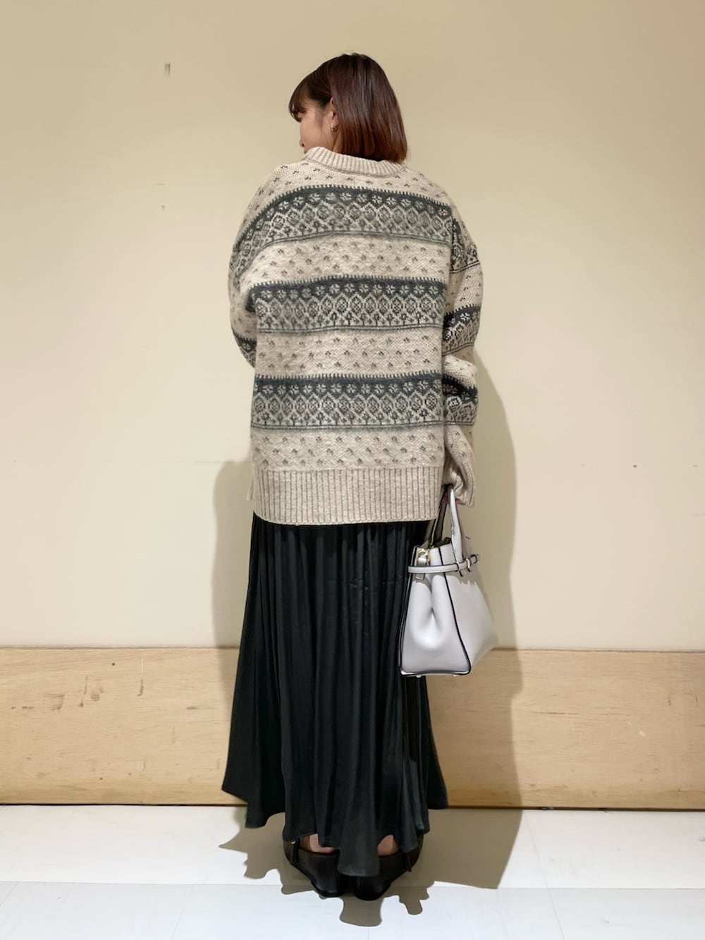 ベージュ系のニット/セーター、グレー系のスカート、ブラック系のその他シューズを着用したレディースの冬コーディネートの8枚目の写真