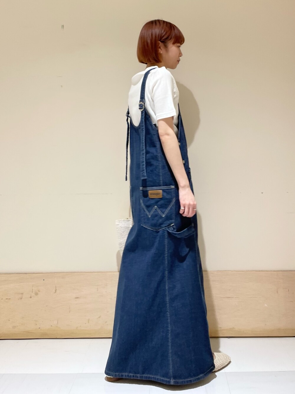 ホワイト系のハンドバッグ、ホワイト系のTシャツ/カットソー、ブルー系のワンピースを着用したレディースの春コーディネートの4枚目の写真