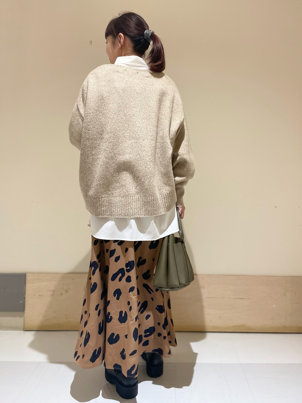 ベージュ系のニット/セーター、ホワイト系のシャツ/ブラウス、イエロー系のスカートを着用したレディースの冬コーディネートの4枚目の写真