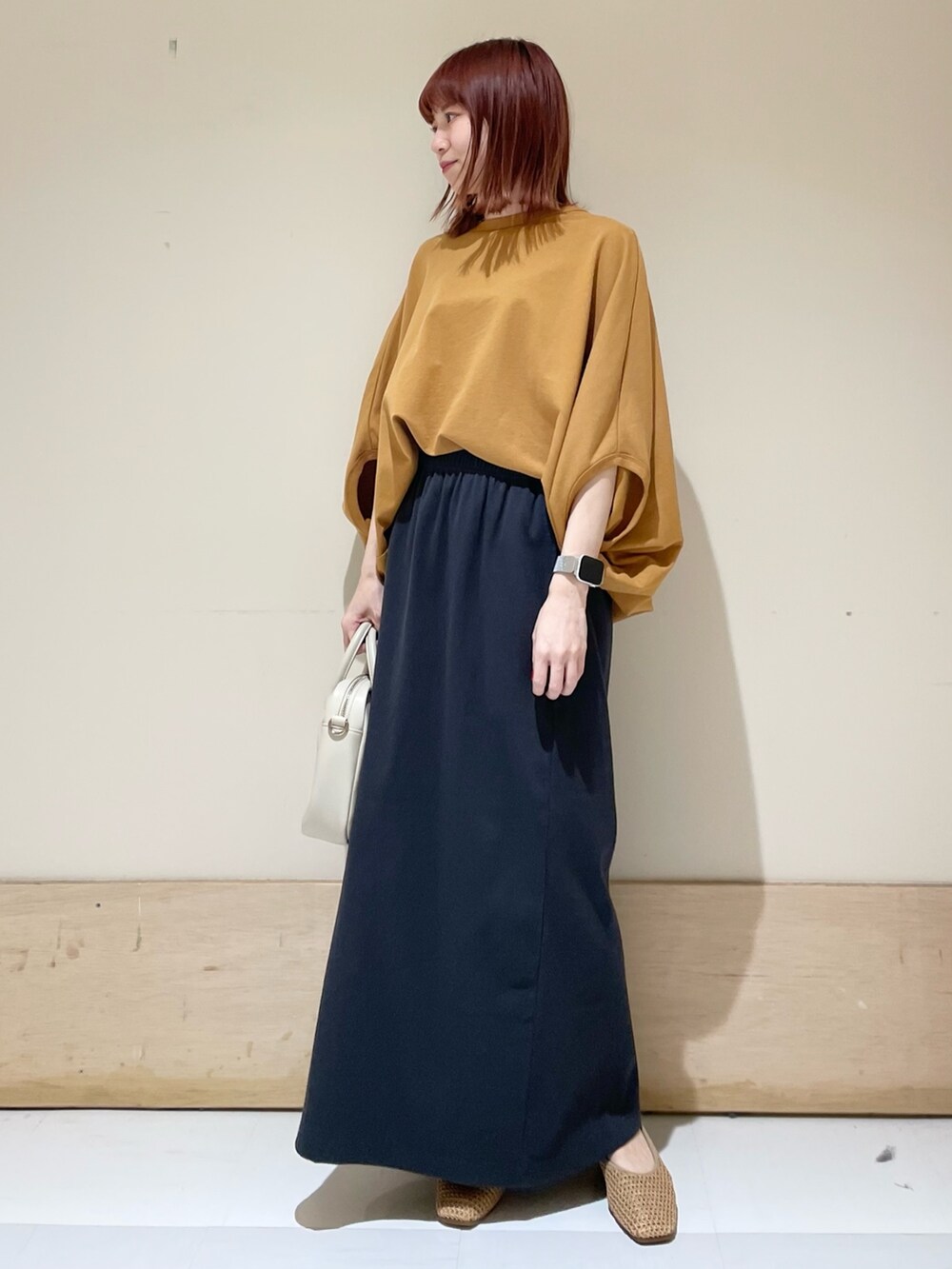 イエロー系のTシャツ/カットソー、ベージュ系のパンプス、グレー系のスカートを着用したレディースの春コーディネートの4枚目の写真