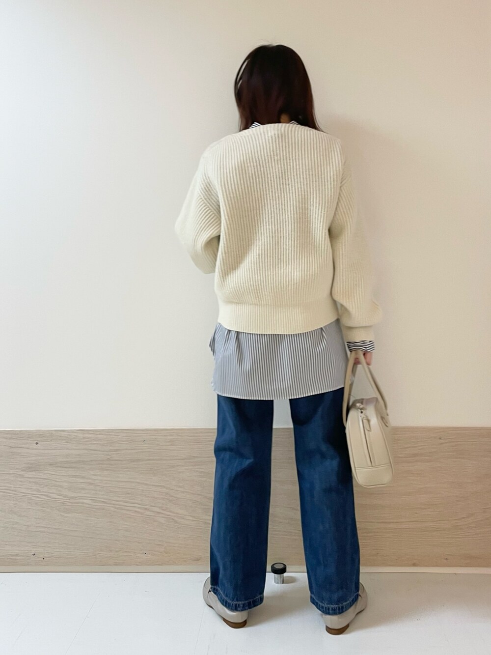 ホワイト系のニット/セーター、ブルー系のデニムパンツ、ベージュ系のボストンバッグを着用したレディースの冬コーディネートの6枚目の写真