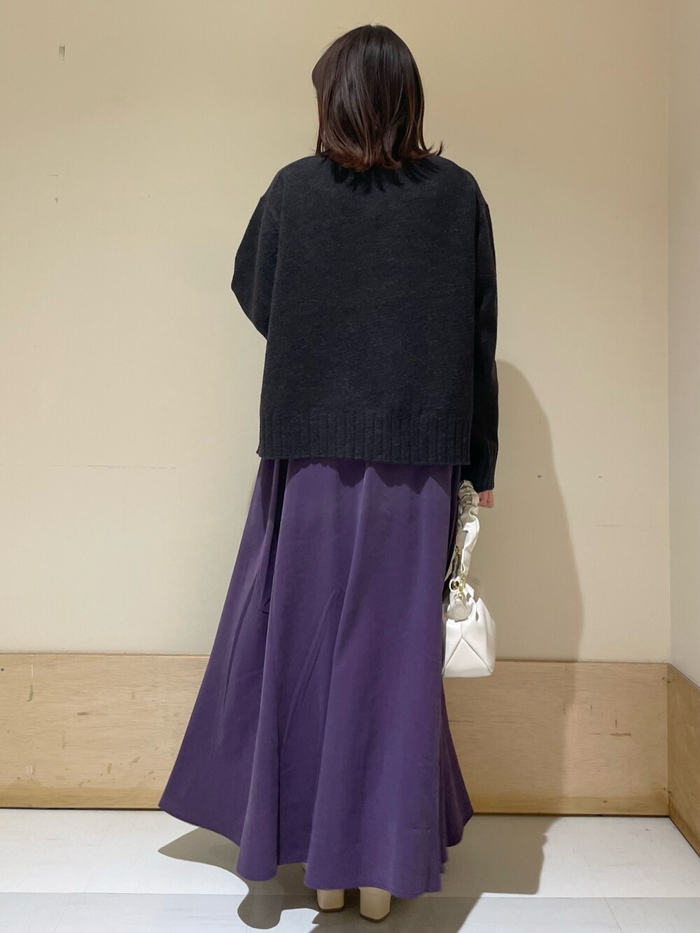 ブルー系のニット/セーター、パープル系のスカート、ホワイト系のハンドバッグを着用したレディースの冬コーディネートの3枚目の写真