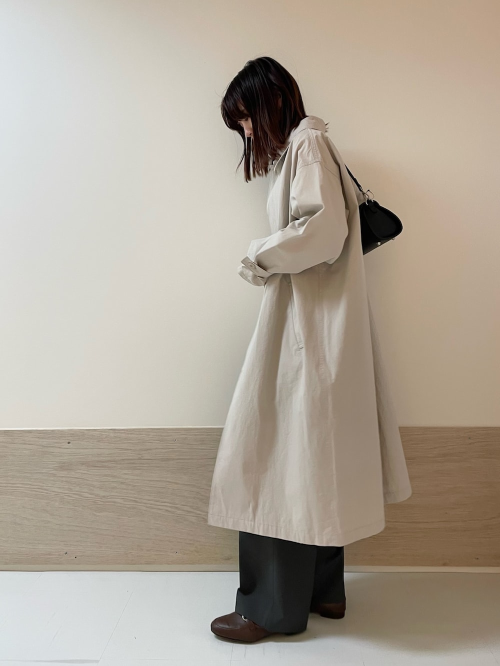 グレー系のその他パンツ、ブラック系のショルダーバッグ、グレー系のステンカラーコートを着用したレディースの春コーディネートの3枚目の写真