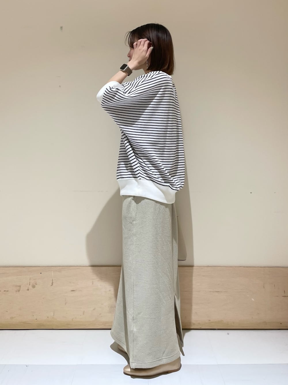 ベージュ系のスカート、ホワイト系のTシャツ/カットソー、ホワイト系のトートバッグを着用したレディースの秋コーディネートの5枚目の写真