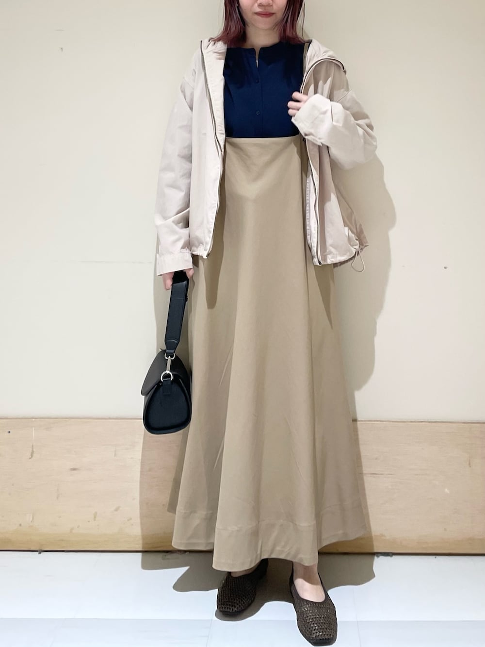 ベージュ系のスカート、ブラウン系のパンプス、ブルー系のカーディガン/ボレロを着用したレディースの春コーディネートの2枚目の写真