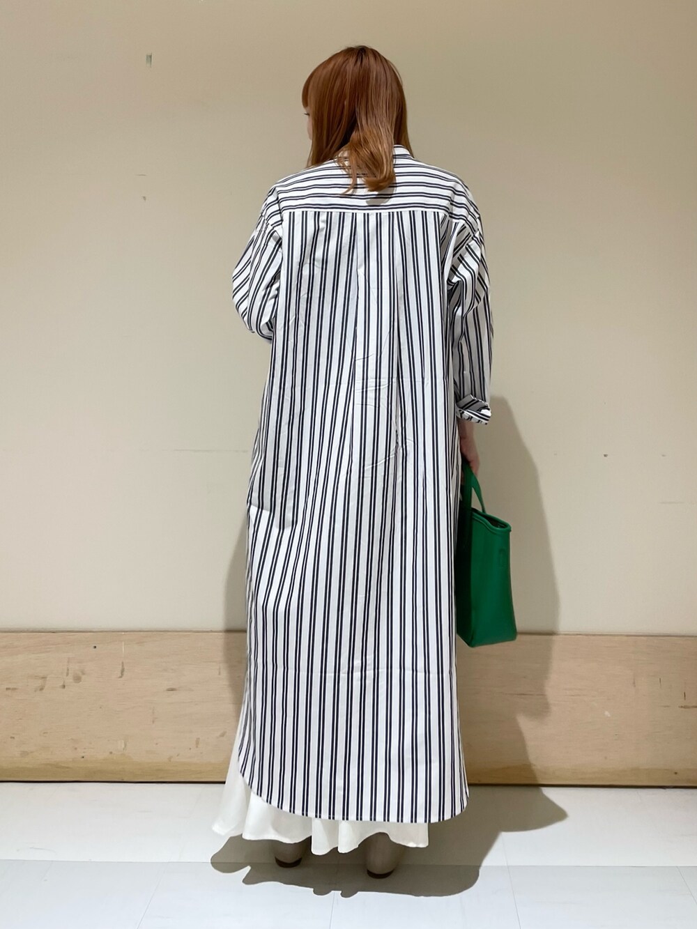 グリーン系のトートバッグ、ベージュ系のパンプス、ブルー系のワンピースを着用したレディースの春コーディネートの5枚目の写真