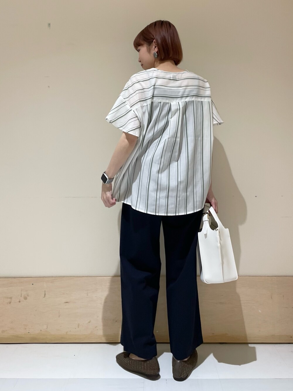 グリーン系のシャツ/ブラウス、ブルー系のその他パンツ、ホワイト系のトートバッグを着用したレディースの春コーディネートの6枚目の写真