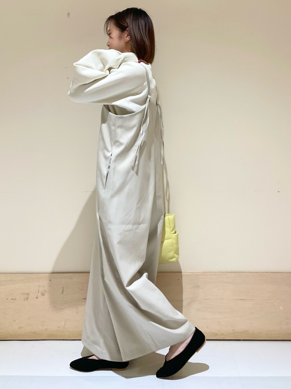 ホワイト系のニット/セーター、ベージュ系のサロペット/オーバーオール、イエロー系のトートバッグを着用したレディースの秋コーディネートの5枚目の写真