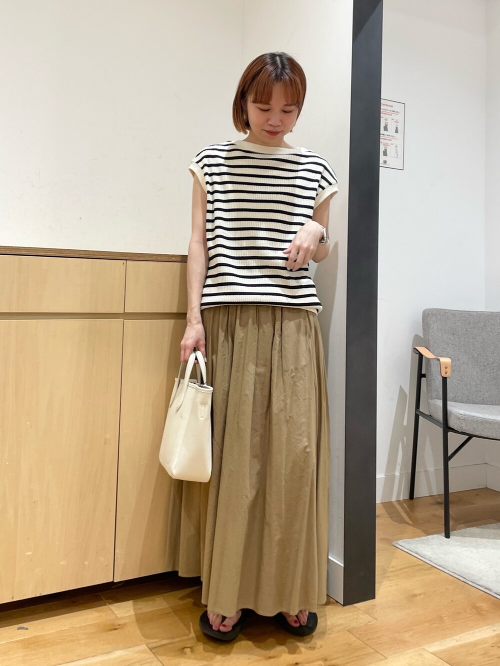 ホワイト系のTシャツ/カットソー、ベージュ系のスカート、ホワイト系のトートバッグを着用したレディースの春コーディネートの2枚目の写真