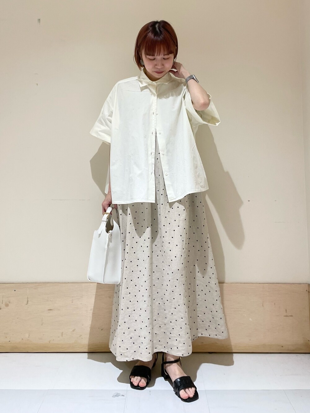 ベージュ系のワンピース、ホワイト系のトートバッグ、ホワイト系のシャツ/ブラウスを着用したレディースの春コーディネートの2枚目の写真