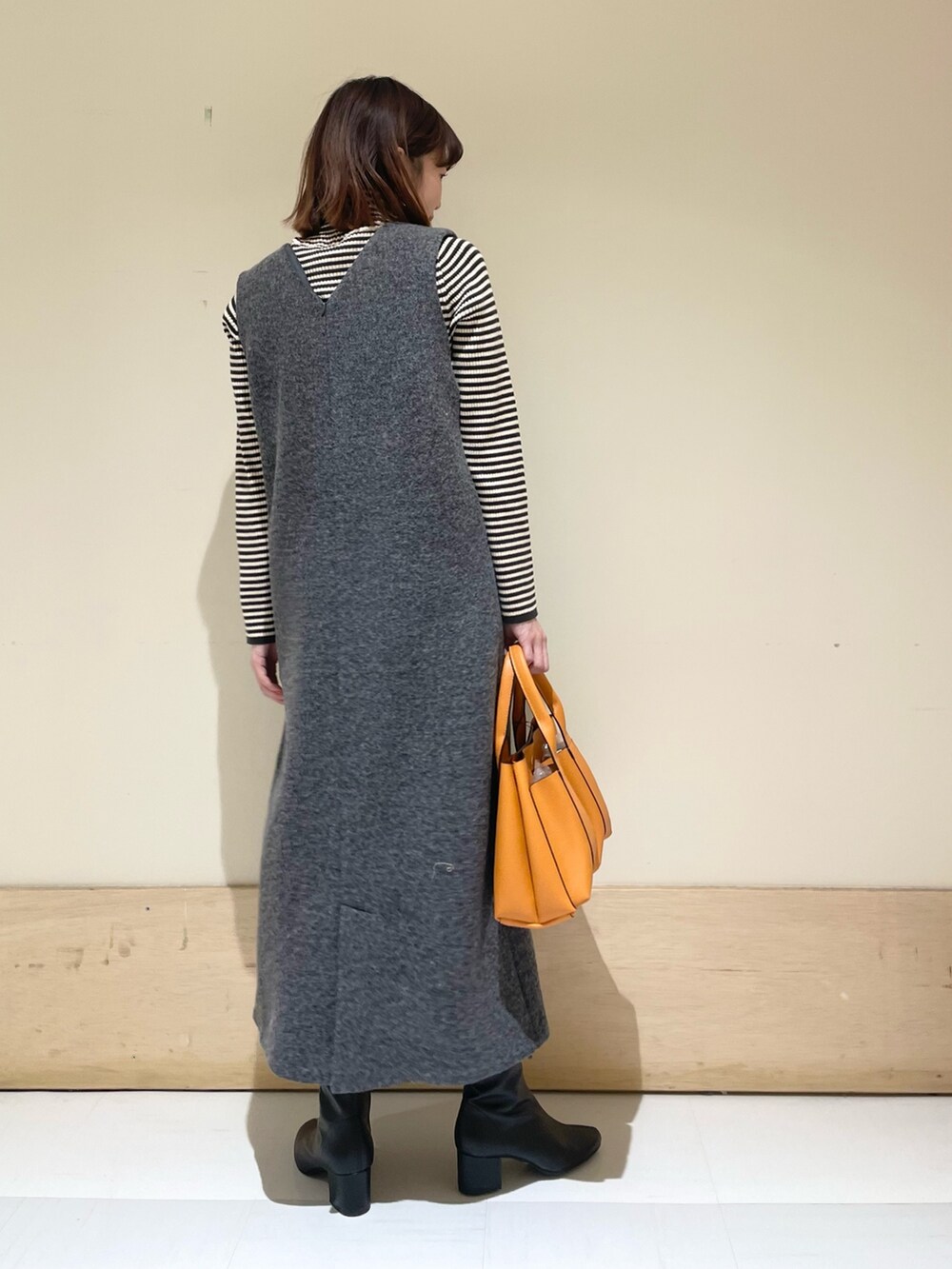 ホワイト系のニット/セーター、グレー系のワンピースを着用したレディースの冬コーディネートの8枚目の写真