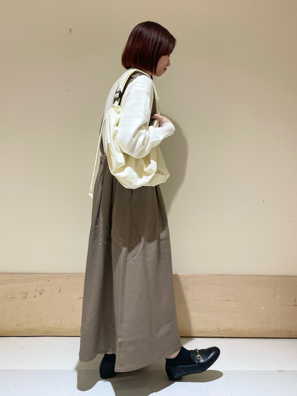 ベージュ系のニット/セーター、ブラック系のローファー、ブラウン系のサロペット/オーバーオールを着用したレディースの秋コーディネートの4枚目の写真